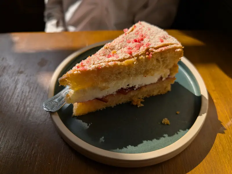 A slice of Victoria sponge with jam and cream